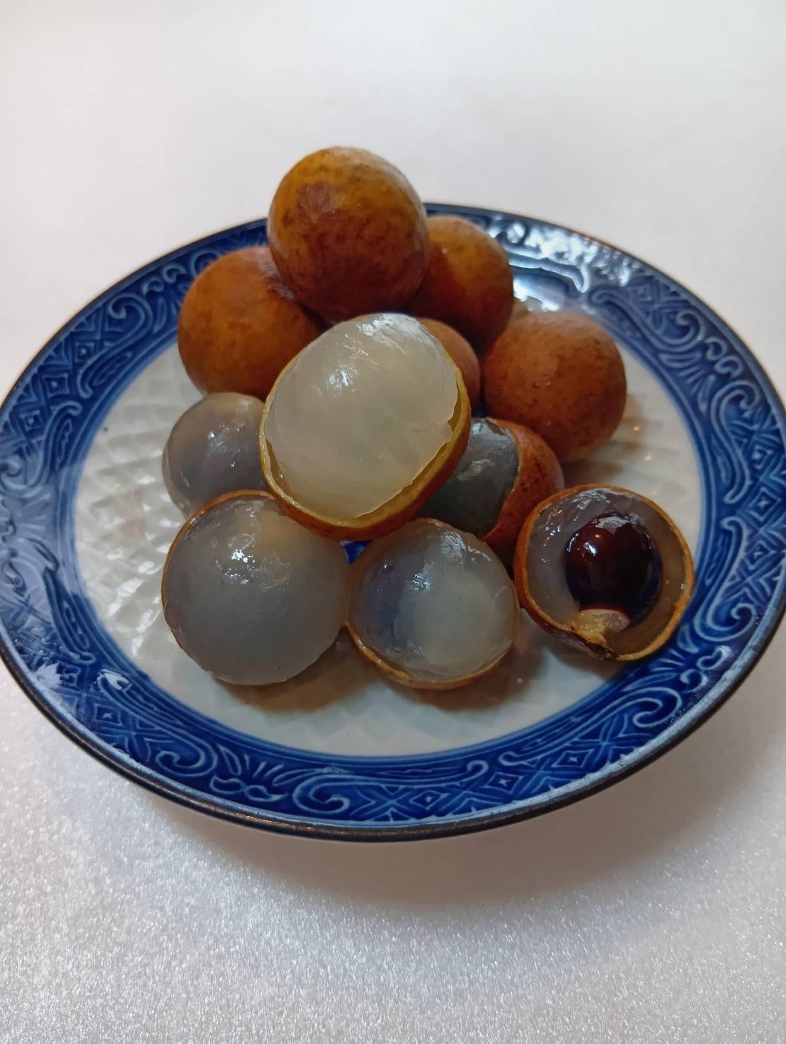 皮をむいた龍眼。半透明の白い果肉と黒い種